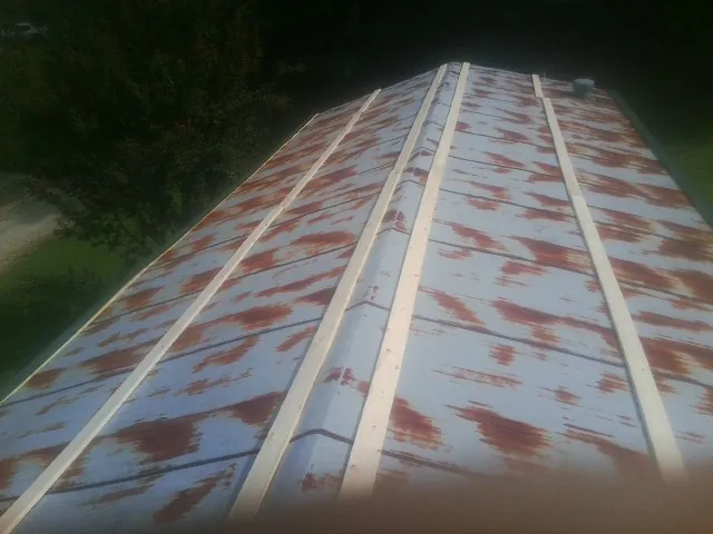 Rusted metal roof panels with new wood purlins before replacement — Storm Damage Roof Repair in Lewisville by Roofing Brothers