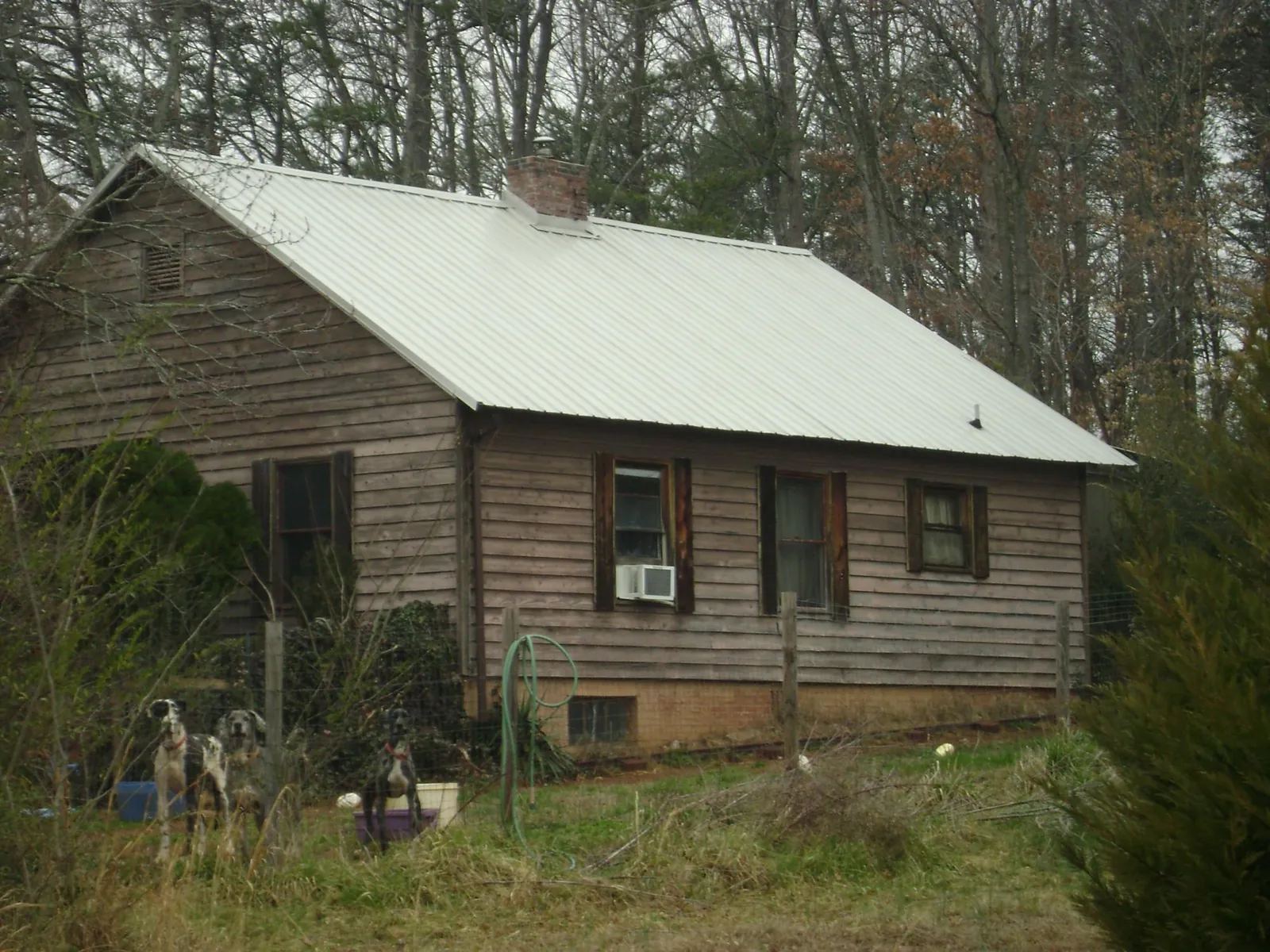 White metal roof on an old wood sided farmhouse, from a Metal Roof Installation job in Lewisville